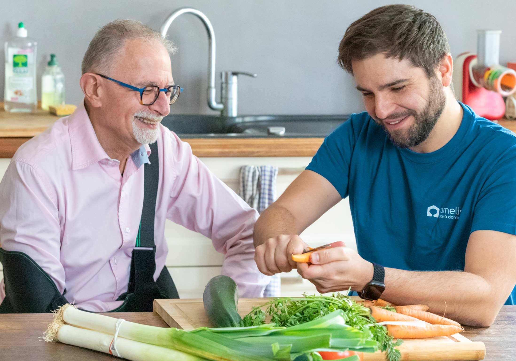 Un homme qui a le bras en écharpe et son aide à domicile cuisinent le repas