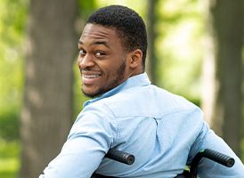 Jeune homme noir assis dans un fauteuil roulant