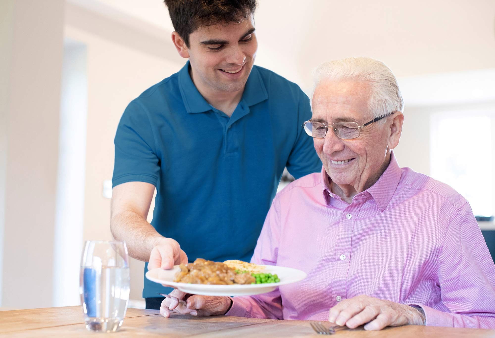 Aide à domicile qui donne le repas à un vieil homme