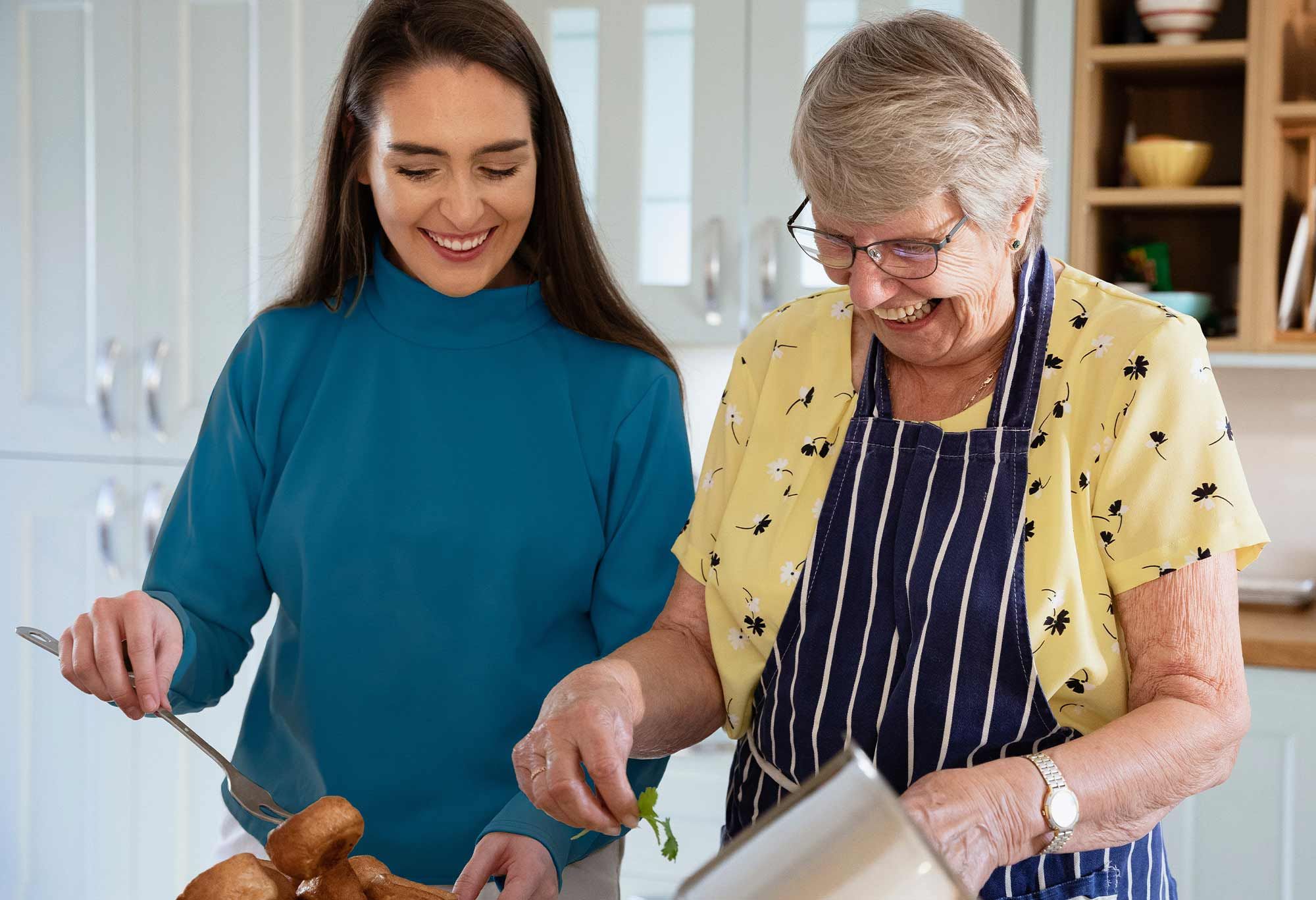 Vieille femme qui cuisine avec son auxiliaire de vie