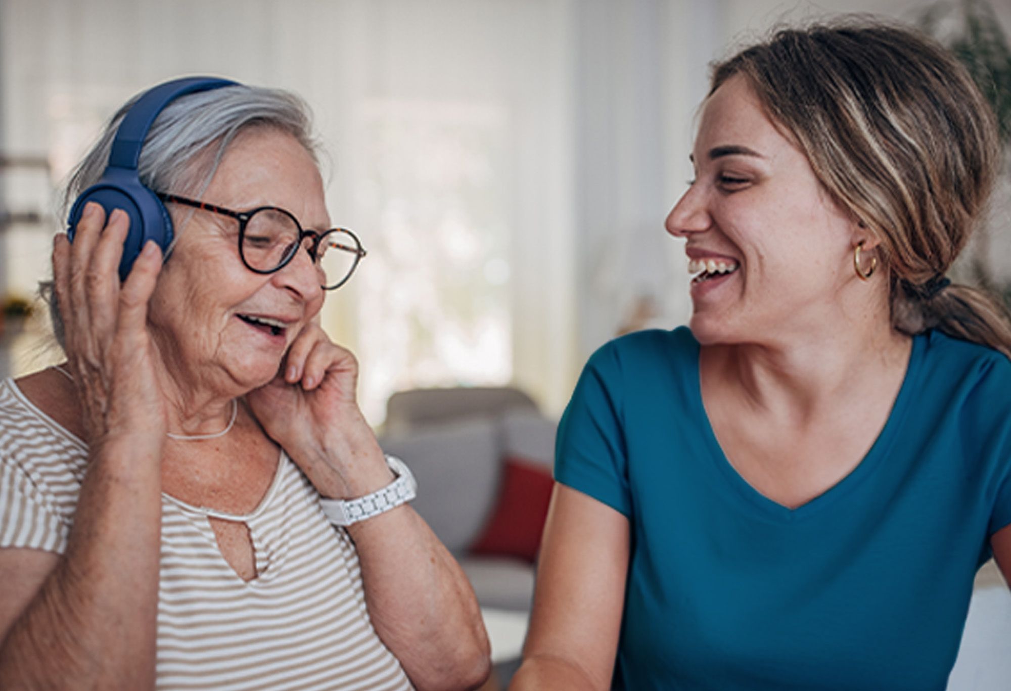 Vieille femme avec son aide à domicile qui écoute de la musique