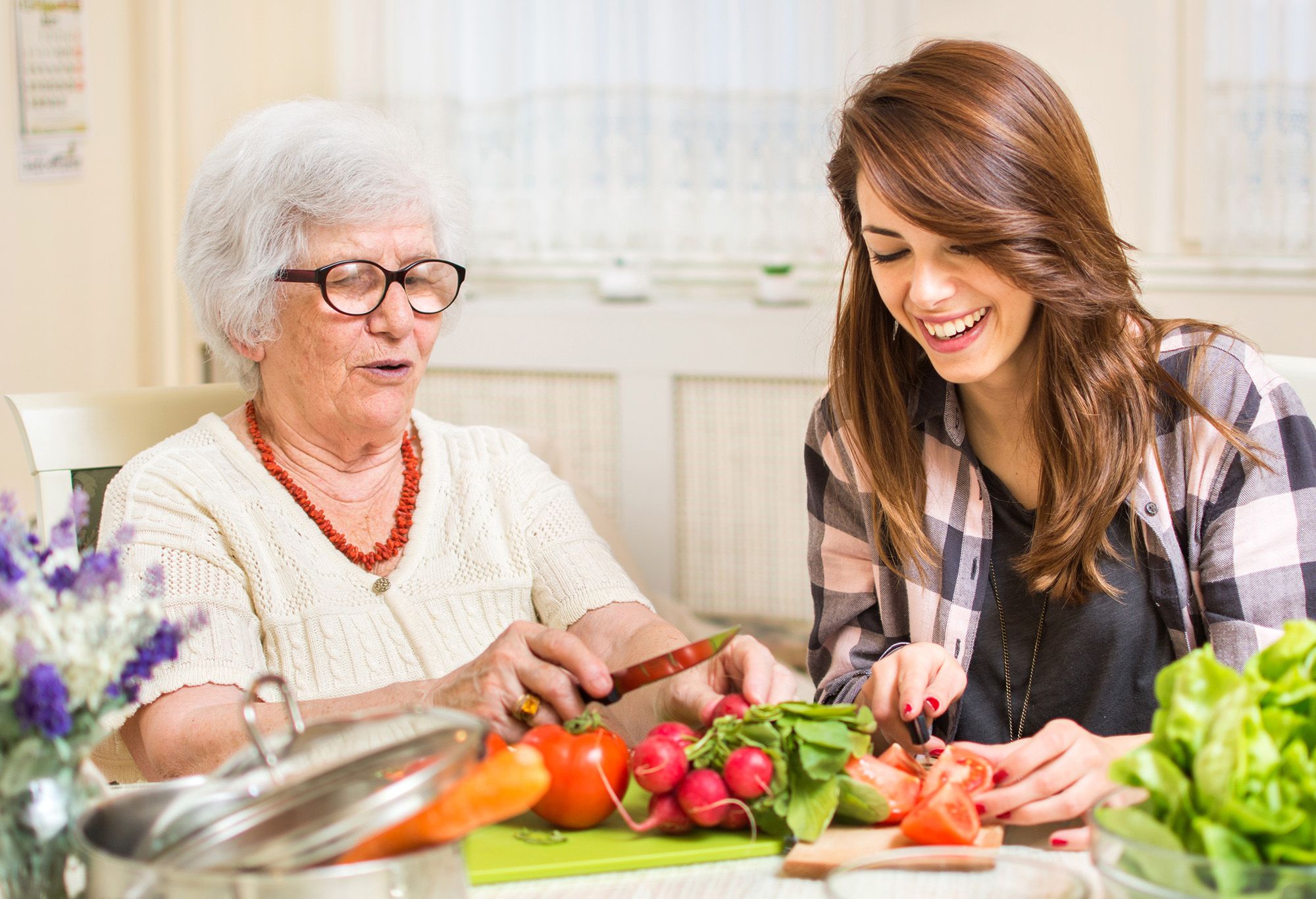 Femme sénior qui cuisine avec son aide à domicile