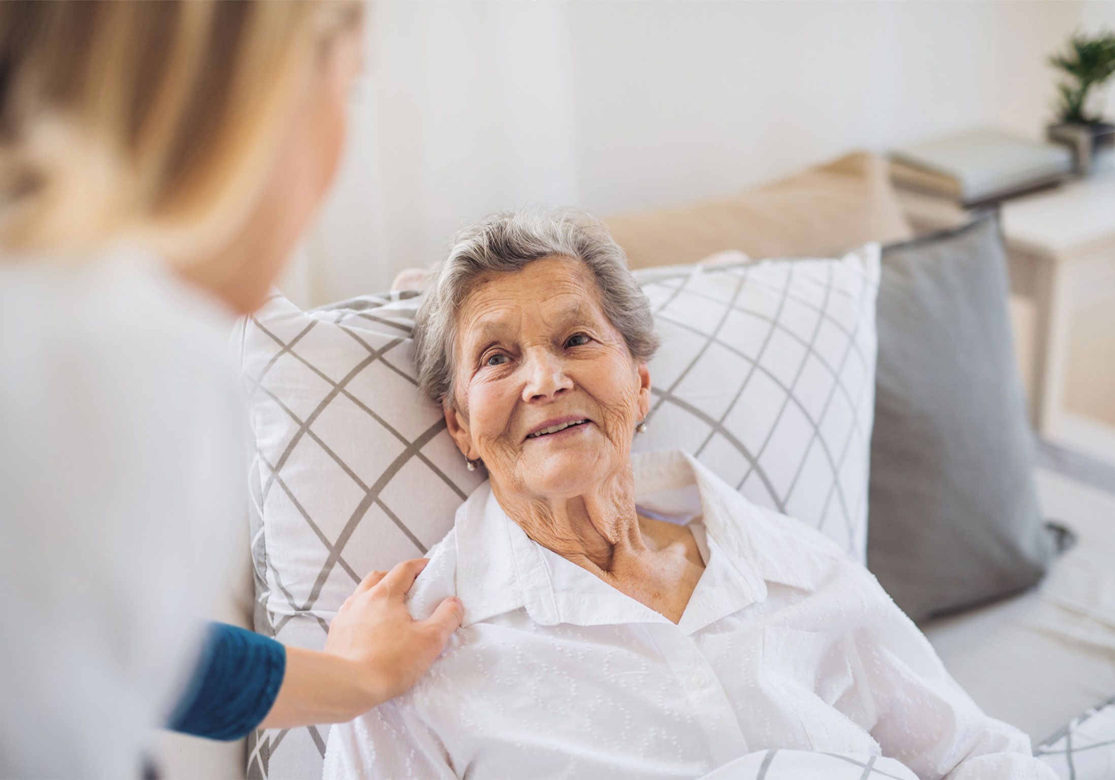 une aide à domicile aide une femme âgée au moment du coucher