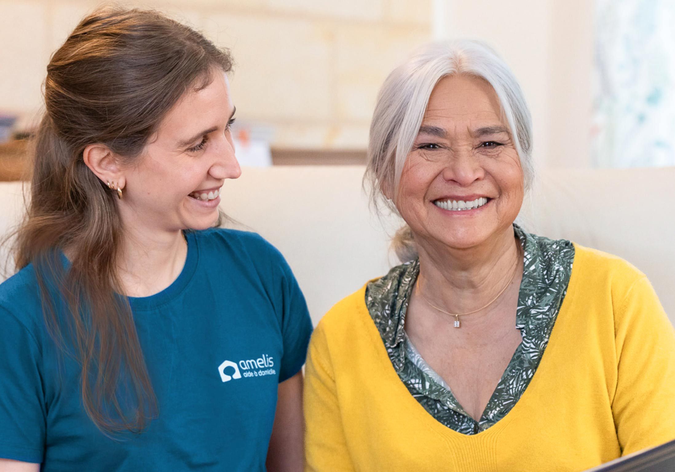 une femme âgée et son aide à domicile sourient