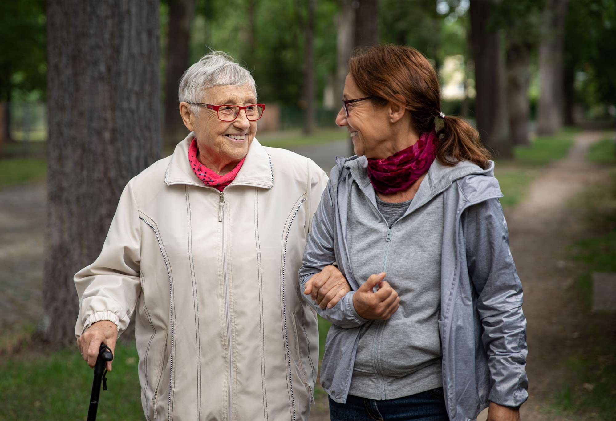 une femme avec une canne se balade avec son auxiliaire de vie