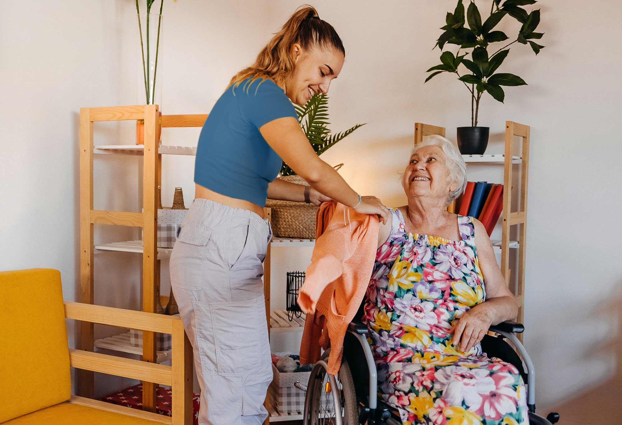 femme auxiliaire de vie qui aide une femme en fauteuil roulant à mettre son manteau