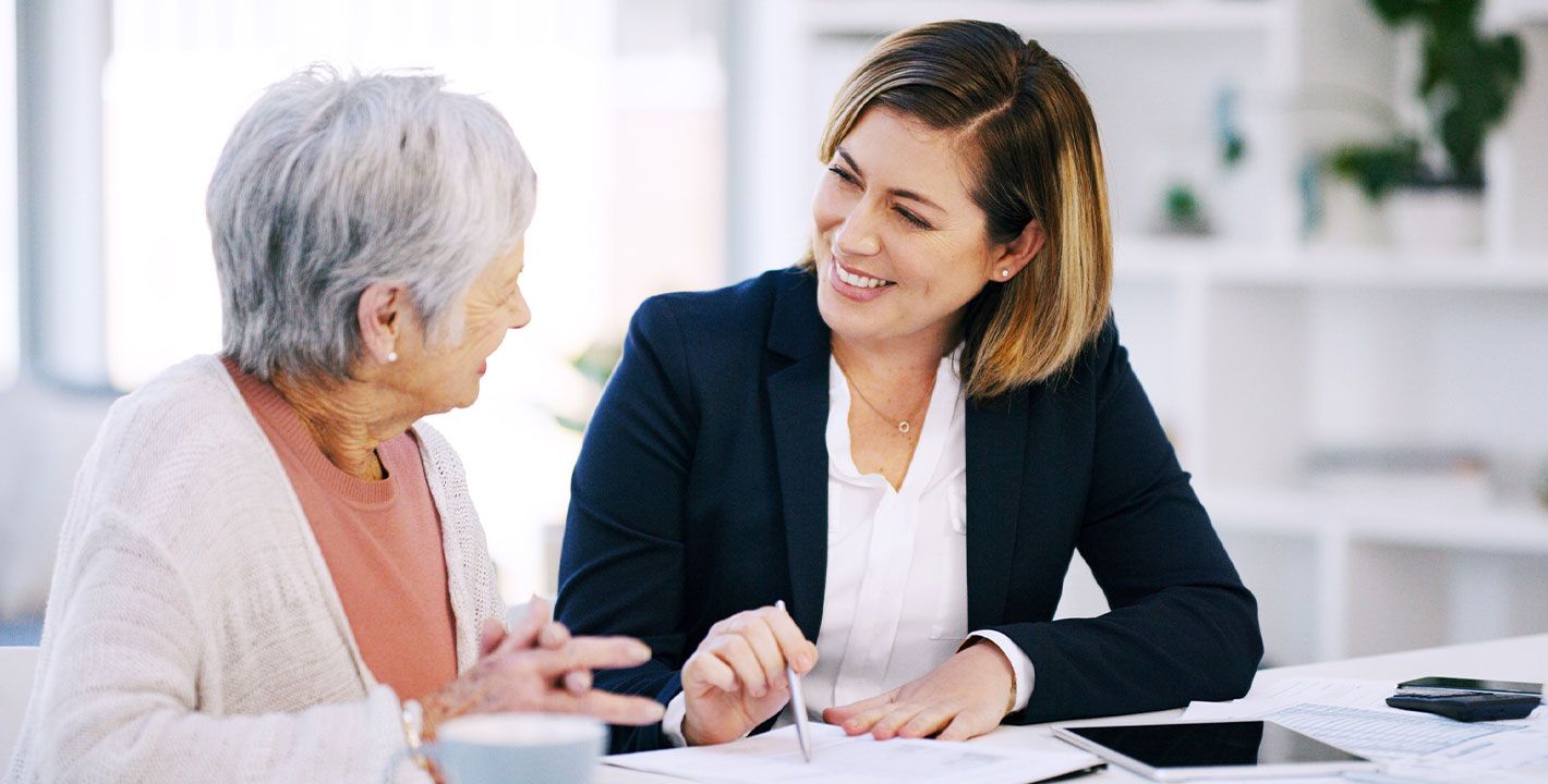 une femme de bureau parle avec une femme âgée 