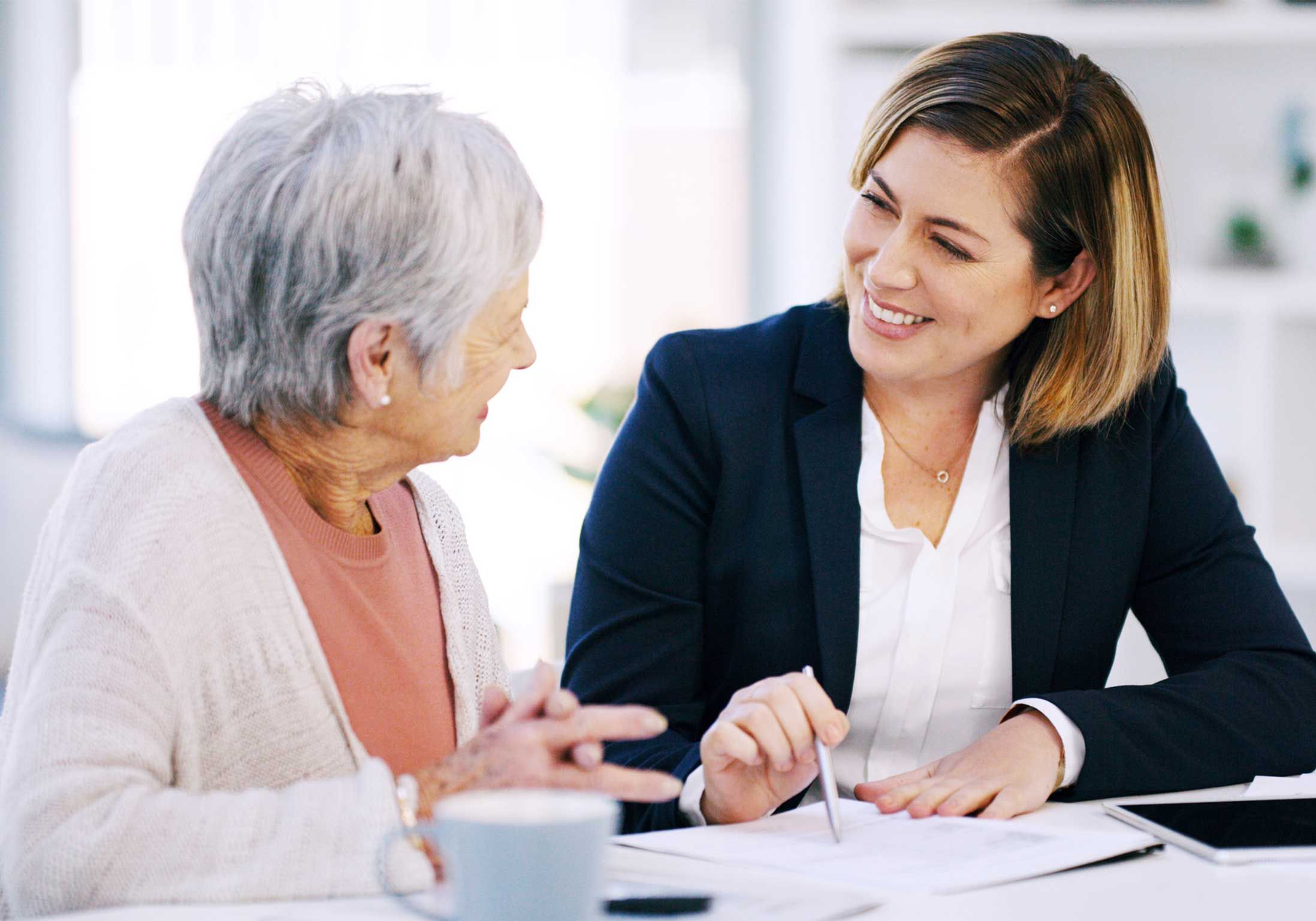 une femme de bureau parle avec une femme âgée 